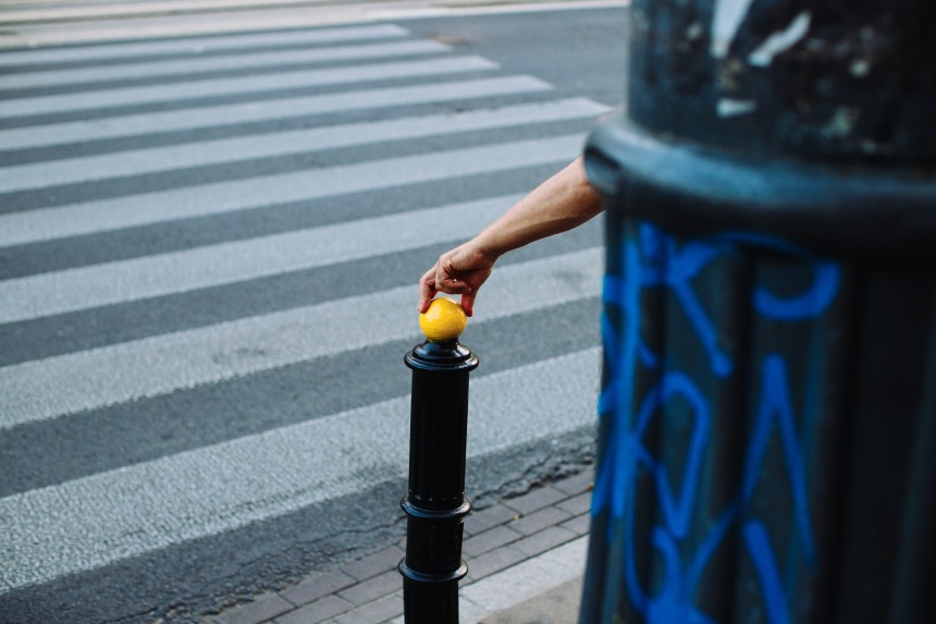 hand on yellow ball at crosswalk